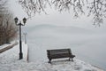 Bench on the banks of frozen lake Orestiada in Kastoria Royalty Free Stock Photo