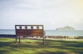 A bench with blurred blue sea and sky in background.Secluded place for near the sea shore.lonely concept.selective focus.