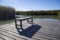 Bench casting shadow on wooden deck