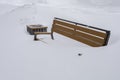 A bench in a city park completely covered with snow, winter weather, a bench hidden under a layer of snow Royalty Free Stock Photo