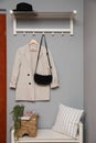 Bench and coat rack on grey wall in hallway. Interior element Royalty Free Stock Photo