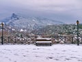 Bench covered in snow and lamp post. Litohoro in Pieria, Greece at winter time. Snow landscape Royalty Free Stock Photo