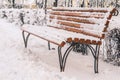 Bench covered with snow in the city in winter