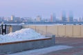 A bench with a flower bed in winter, filled with a snowdrift. Promenade of the city embankment. Blurred in the Royalty Free Stock Photo