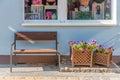 There is a bench with flowers on the street under the window Royalty Free Stock Photo