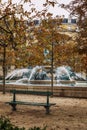 A bench and a fountain in a bright autumn park in Paris. Beautiful landscape. Vertical Royalty Free Stock Photo