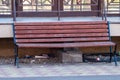 Bench and garbage under it. a plastic glass under a bench