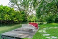 Bench in the garden next to the waterfront in a lush