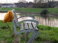 Bench with hat next to river in background