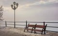 Bench and lantern on foggy winter morning Royalty Free Stock Photo