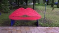 Bench for lips-shaped kisses in a city park. Red lips