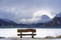 Bench looking solitary at frozen Sils lake in Engadin Switzerland with snow Alps mountains Royalty Free Stock Photo