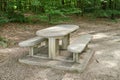 A bench made of concrete and ceramics outside in a luscious green forest during summer or spring. A quiet place to enjoy