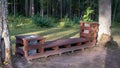 Bench made of windows. Wooden bench in a summer park. Sunny day in the forest on the nature. Wood decor. Trash bin or Royalty Free Stock Photo