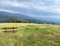 A bench in a meadow in front of the mountain shelter in Hala Rysianka in Beskid Zywiecki in Poland, where you can sit and admire