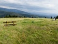 A bench in a meadow in front of the mountain shelter in Hala Rysianka in Beskid Zywiecki in Poland, where you can sit and admire