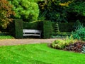 Bench in nicely trimmed bushes in Regent's park, London. Landscape design Royalty Free Stock Photo