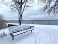 Bench by a North American Lake covered in snow.