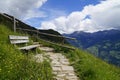 bench over alpine valley of city Merano surrounded by Texel group mountains (Oetztaler Alpen, South Tyrol, Italy)