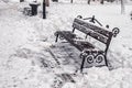 A bench in the park covered with snow in winter Royalty Free Stock Photo