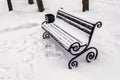 A bench in the park covered with snow in winter Royalty Free Stock Photo