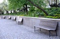 Wooden bench near the edge of the path in the park pedestrian blocks pavement retaining wall low metal frame benches elegant shape Royalty Free Stock Photo