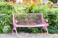 Bench in park - pink vintage bench chair in the garden with green plant and flower background in the summer Royalty Free Stock Photo