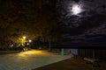 Bench in the park under moonlight and poles. Royalty Free Stock Photo