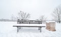 Wooden bench and concrete garbage or junk can on the street or in the park covered with snow in the winter season Royalty Free Stock Photo