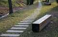 Bench prism of one piece of trunk painted in the park pedal road made of concrete tiles in lawn straight row concrete walkway in c Royalty Free Stock Photo