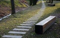 Bench prism of one piece of trunk painted in the park pedal road made of concrete tiles in lawn straight row concrete walkway in c Royalty Free Stock Photo