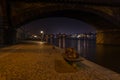 A bench on the promenade on the bank of the Moldava river at night, Prague, Czech Republic