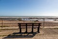 A bench on a promenade with a view out to sea, at Pett Level on the Sussex coast