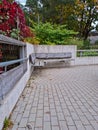 Bench at the public park. Modern recreation place. Pathway in perspective. Concrete and timber in modern architecture Royalty Free Stock Photo