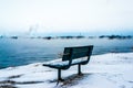 Bench by the river foggy winter day Royalty Free Stock Photo