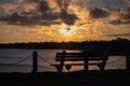 Bench with scenic orange sunset and seascape in the background at the Charleston harbor Royalty Free Stock Photo