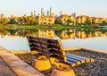 Bench on the shore of the lake with the reflections of buildings and trees in Dubai, UAE Royalty Free Stock Photo