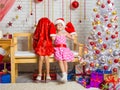 On the bench sits a girl in a cap and mittens of Santa Claus, the other girl wore a bag on his head Royalty Free Stock Photo