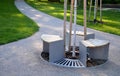 Bench sitting round with wood paneling gray metal plate three seats around a tree around a gravel threshing path in the park lawn