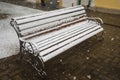 A bench smoothly covered with fresh snow after weather phenomena