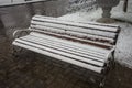 A bench smoothly covered with fresh snow after weather phenomena