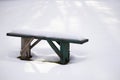 Bench with snow cap over a snow background Royalty Free Stock Photo