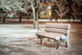 Bench with snow after snowstorm or in snow calamity in europe, winter night photograhy in city Royalty Free Stock Photo
