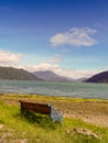 A bench stands by the coast of a fjord in Patagonia in Chile.