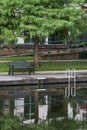 The Woodlands, Texas USA - July 11, 2021: A green bench under a cypress tree on the Waterway.