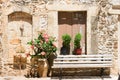 Bench and vase with roses near stone wall