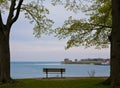 A bench at the water`s edge in Queen`s Royal Park Royalty Free Stock Photo