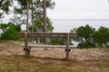 Bench wooden in the park pine forest with lake view in summer day on Hourtin coast France Royalty Free Stock Photo