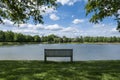 Benche front of lake in city park with blue sky landscape in summer park bench, beautiful garden bench, concept of rest, nobody in Royalty Free Stock Photo