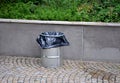 Benches by a load-bearing gray concrete retaining wall in a park. Above the wall in the flower bed. wooden park bench with metal b Royalty Free Stock Photo